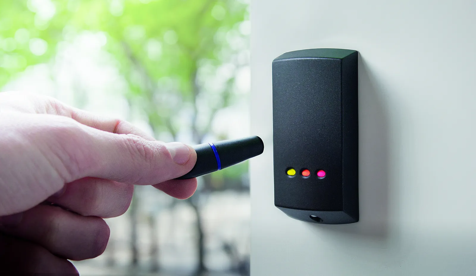 Keypad and fob access control reader beside an office door