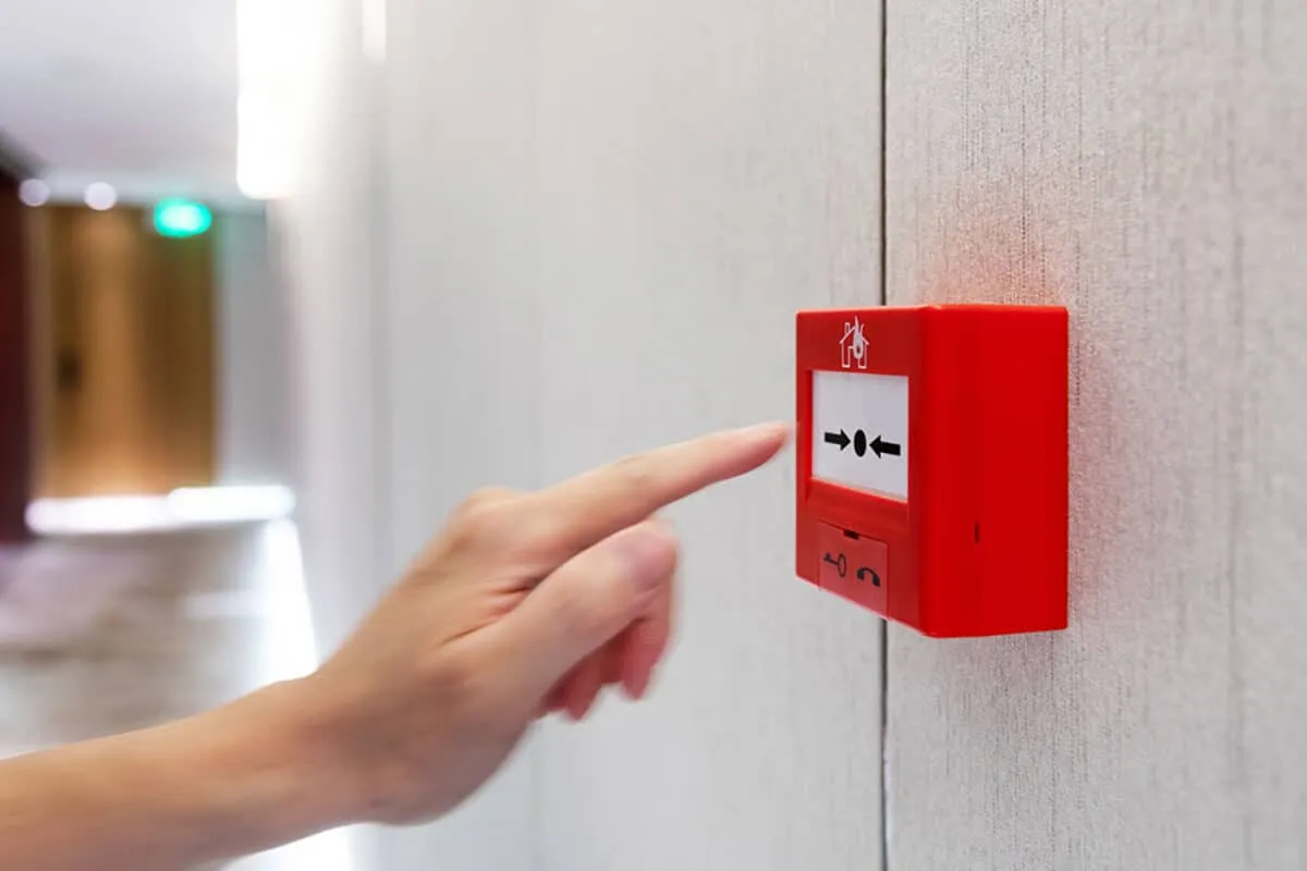 Engineer testing a fire alarm call point during a BS 5839-1 service visit